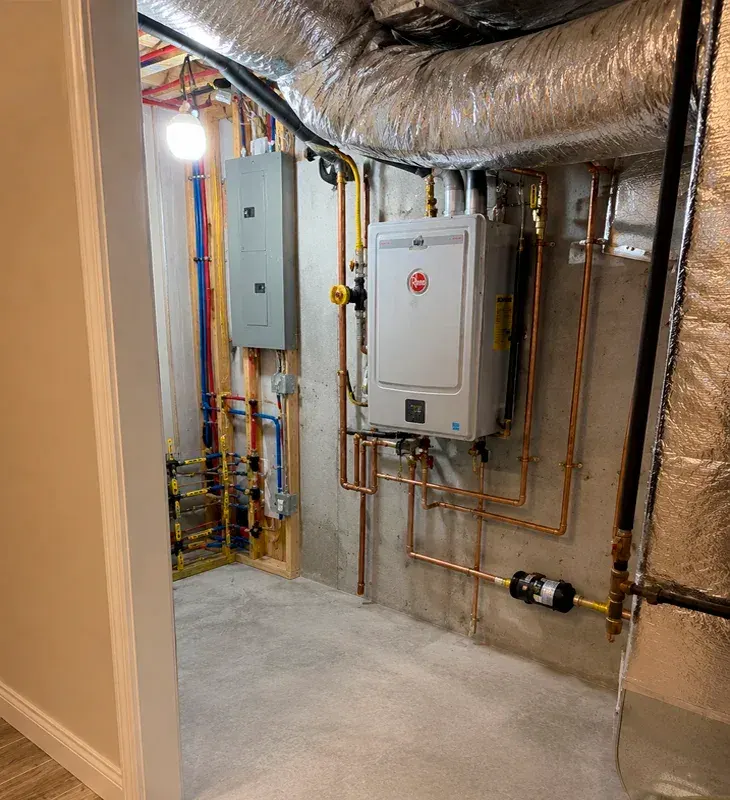 Professional installation of a Rheem high-efficiency water heater and heating system in a utility room in Oxnard, CA. Complete setup with modern piping and controls.