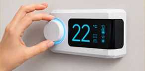 Hand adjusting a modern smart thermostat displaying 22°C