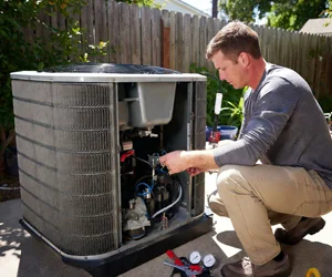 Professional HVAC technician servicing and repairing an outdoor air conditioning unit in Chatsworth, California