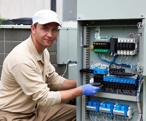 Professional HVAC technician performing electrical work on HVAC control panel in Woodland Hills, California